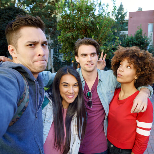 Group selfie of two male and two female college friends in outdoor park