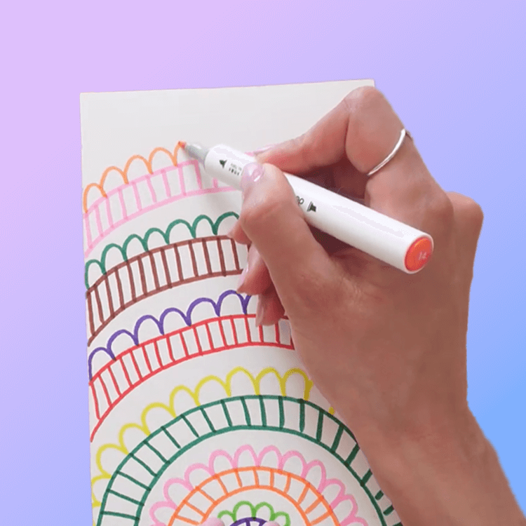 A hand drawing a colorful rainbow on paper